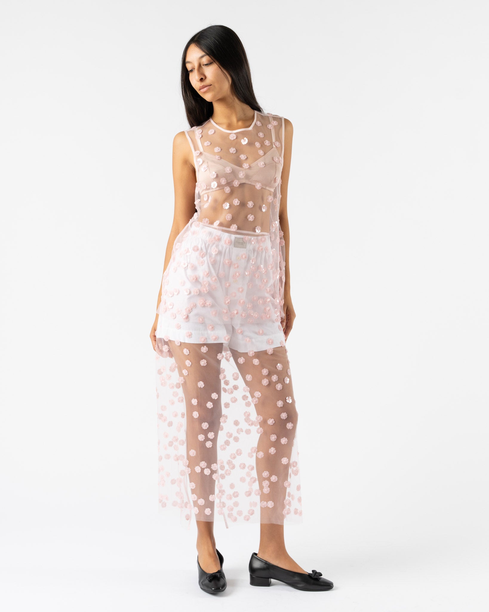 Woman wearing a sheer polka dot outfit on a white background