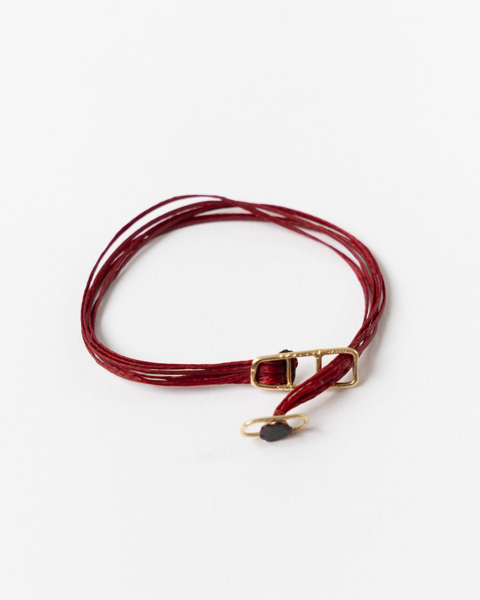 Red leather choker with gold clasp on a white background